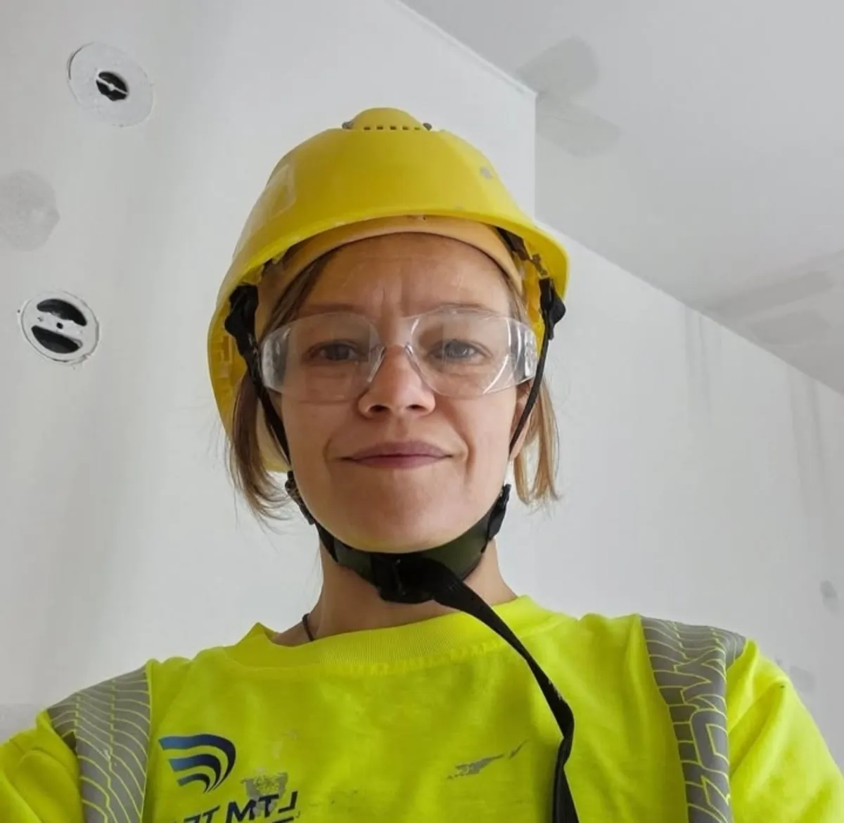 Maria työvaatteissa ja suojakypärässä